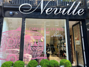 Storefront with 'Neville' branding and a pink decorative object.