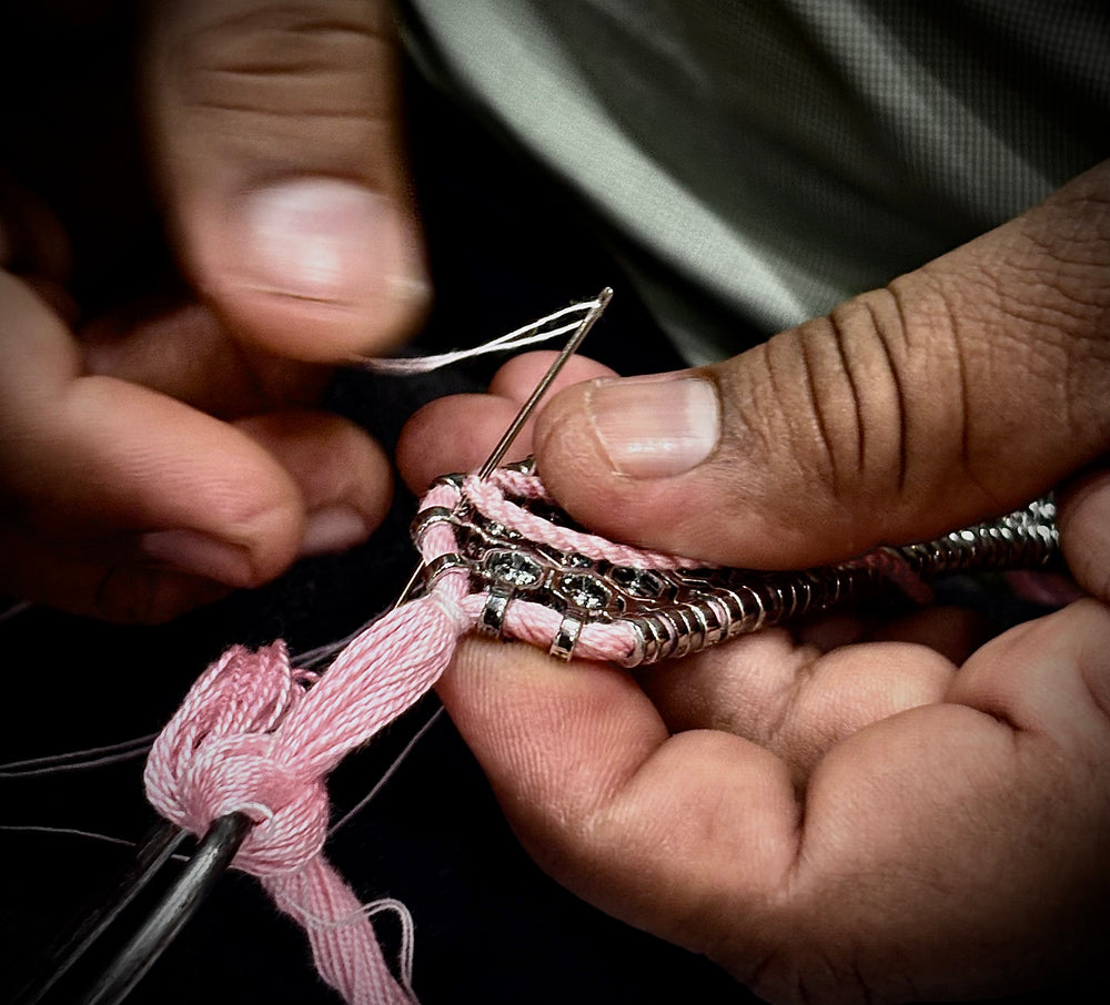 Caravan of Stones artisan hand-sewing the thread of a pavé diamond bracelet