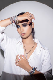 Model in a white shirt wearing The Diamond Ring in Linhasita with The LOVE Necklace and diamond thread bracelets