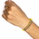 Neon yellow Mini Lisse bracelet with multicoloured gemstones worn on a wrist