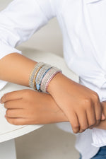 Woman in a white shirt wearing pale diamond Stacker bracelets on both wrists