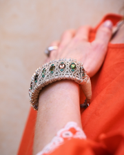 Sand-thread natural diamond and multicoloured gemstone bracelet worn with coral silk