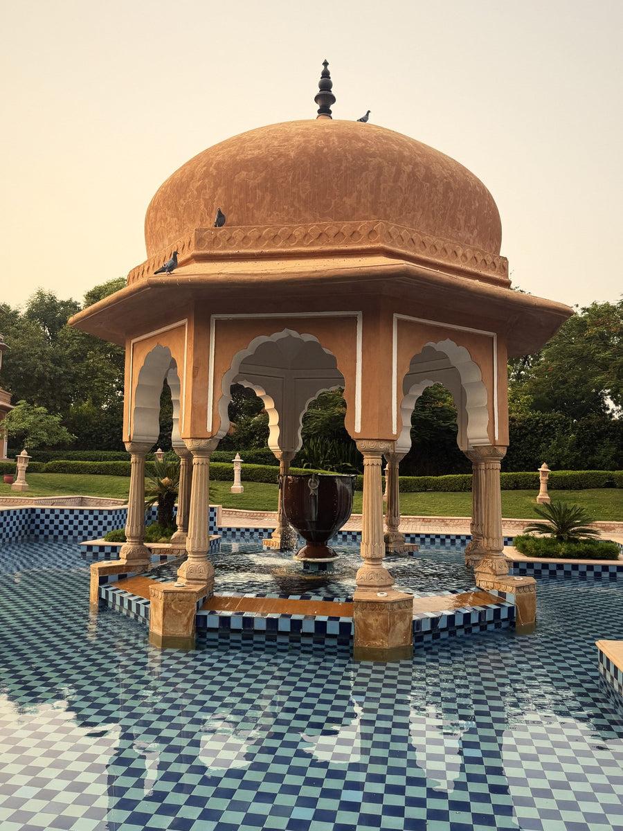 A domed sandstone pavilion rising from a blue-tiled pool at The Oberoi Rajvilas, Jaipur