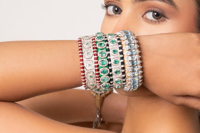 Sophisticated woman wearing a layered stack of natural diamond and coloured-stone thread bracelets
