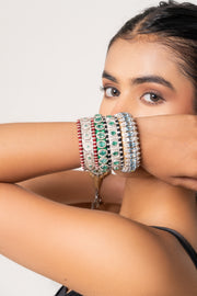 Sophisticated woman wearing a layered stack of natural diamond and coloured-stone thread bracelets