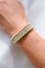 Close-up of a luxury handmade gold thread bracelet with real diamonds on a woman's wrist.