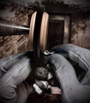 Close-up of hands working on a mechanical component with a rusty background