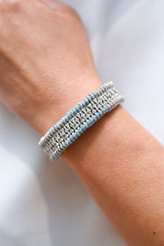 Close-up of a luxury handmade blue thread bracelet with real diamonds on a woman's wrist.