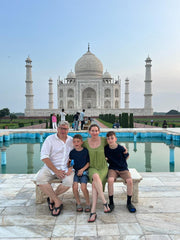 Four people posing in front of the Taj Mahal