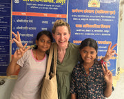 Adult and two children standing in front of a Samarpan Sansthan sign in Jaipur