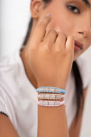 Woman wearing stacked sky blue, sand and pink diamond thread bracelets by Caravan of Stones