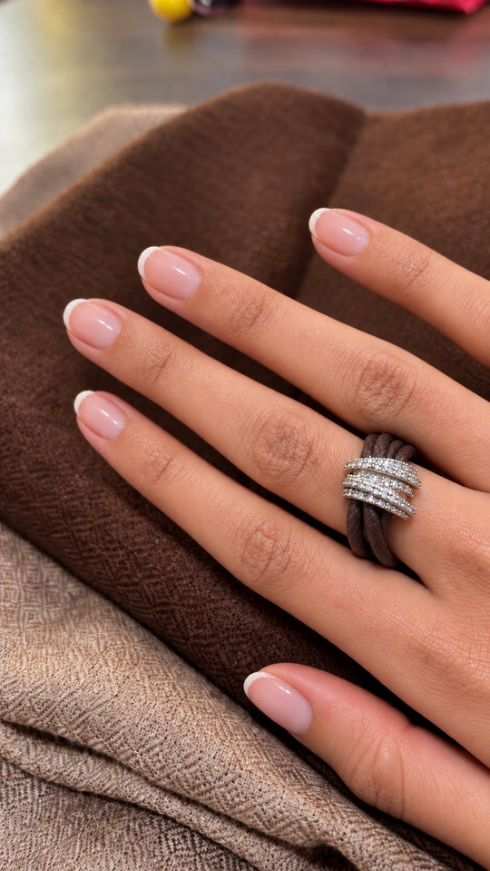The Diamond Ring in Cotton worn on the hand: brown braided cotton cord through a pavé diamond sterling silver band