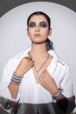 Model in a white shirt wearing The LOVE Necklace with stacked diamond thread bracelets