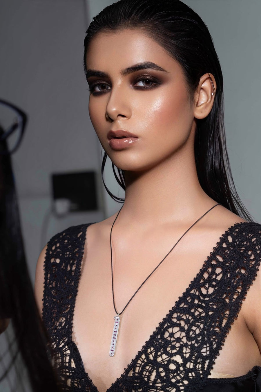 Model in black lace wearing The LOVE Necklace by Caravan of Stones: a sterling silver pendant pavé-set with diamonds, rubies spelling LOVE in Morse code