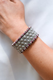A close-up of a person's wrist wearing a caravan-of-stones-st-moritz-vampire-claret-pave-diamond-bracelet.