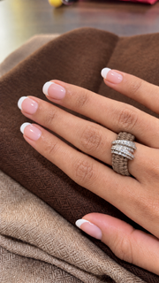The Diamond Ring in Saddle Camel Linhasita by Caravan of Stones, with a continuous knotted thread band and pavé diamond silver detail, worn on a hand.