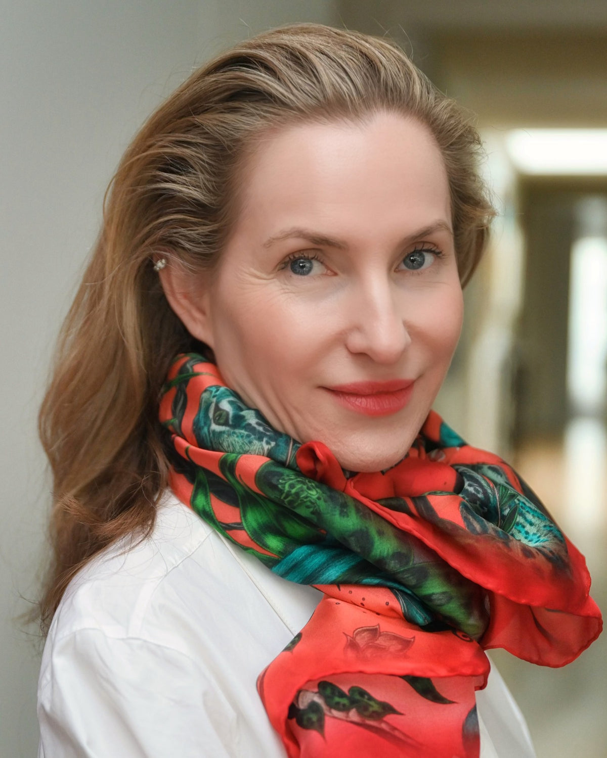 Caron Bluestone, founder of Caravan of Stones, in a white shirt and colourful silk scarf