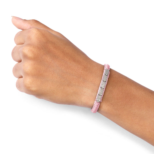 Hand wearing a Méridien baby pink bracelet on a white background