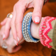 Mykonos sky blue thread pavé diamond bracelet worn on a wrist beside pink knitwear