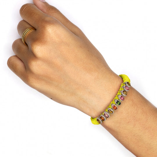 Neon yellow Mini Lisse bracelet with multicoloured gemstones worn on a wrist