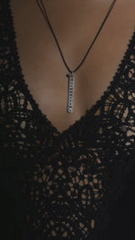 The LOVE Necklace by Caravan of Stones worn over black lace: pavé diamond sterling silver pendant with rubies spelling LOVE in Morse code, on a black cord