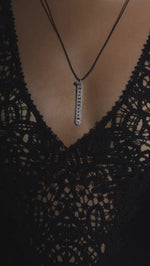 The LOVE Necklace by Caravan of Stones worn over black lace and down the back: pavé diamond pendant with rubies spelling LOVE in Morse code, on a slim cord