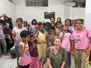 Adult seated among a group of children at Samarpan Sansthan in Jaipur