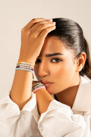 Woman wearing a stack of multi-coloured diamond thread bracelets by Caravan of Stones