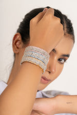 Woman in a white shirt wearing pale diamond Stacker bracelets in a portrait