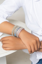 Woman in a white shirt wearing pale diamond Stacker bracelets on both wrists