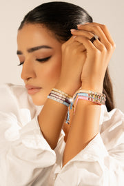 Woman in a white blouse wearing pastel Mini Lisse bracelet stacks on both wrists